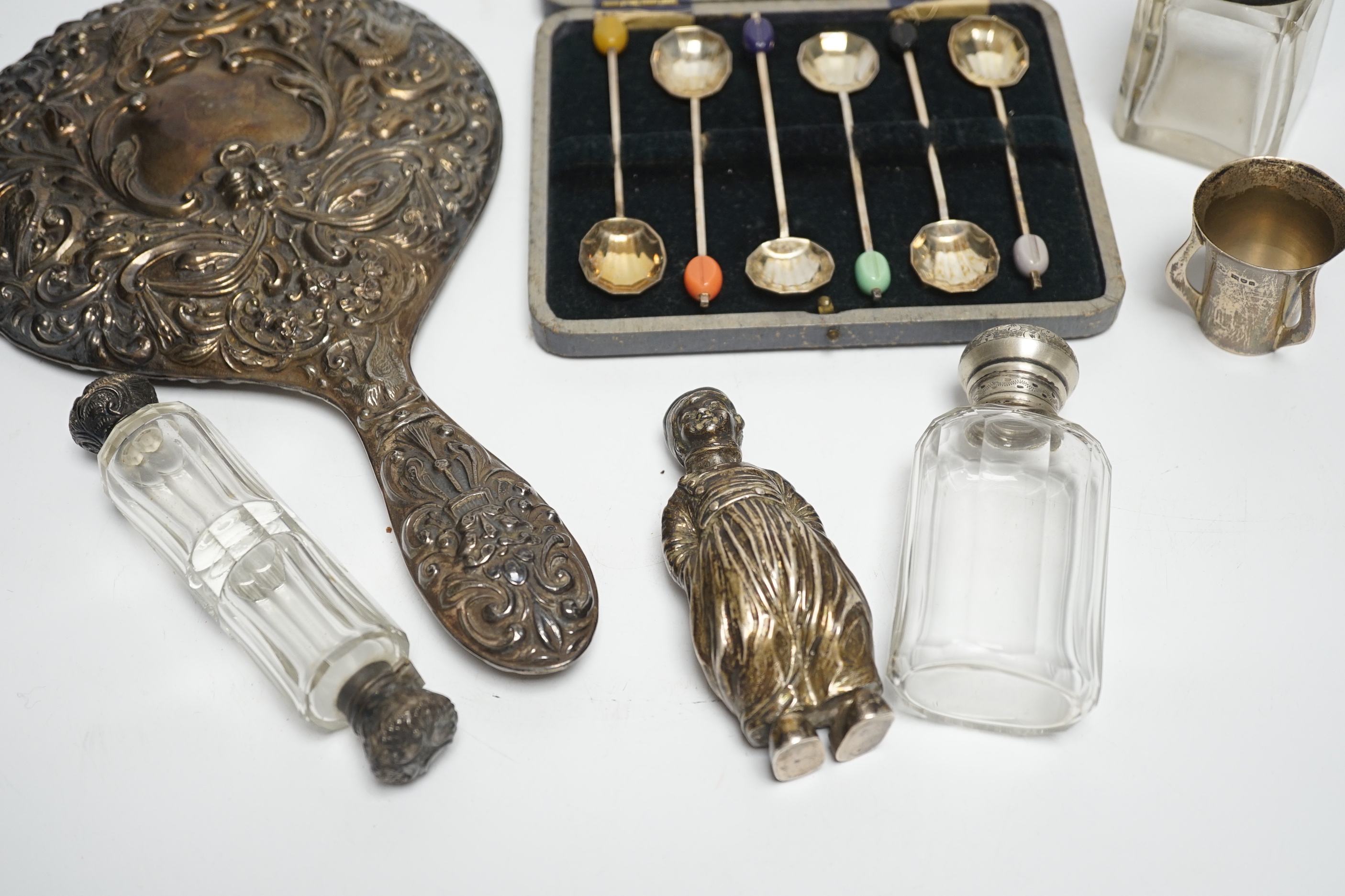 A Hanau silver novelty figural pepperette and other small silver including a silver mounted hand mirror, scent bottles and a small tyg and a cased set of plated spoons.